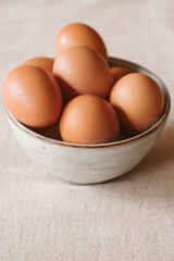 Eggs background. Closeup view of eggs in a bowl on rustic table as background. Organic and healthy food.	