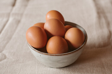 Eggs background. Closeup view of eggs in a bowl on rustic table as background. Organic and healthy food.	