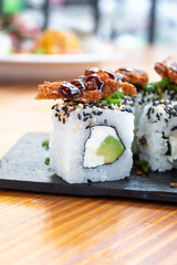 sushi roll on a black plate on a wooden table