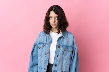 Fototapeta premium Teenager Ukrainian girl isolated on pink background with sad expression