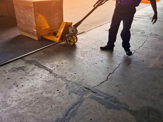 Worker driving forklift loading shipment carton boxes goods on wooden pallet at loading dock from container truck to warehouse cargo storage in freight logistics, transportation industrial, delivery