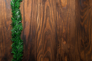 Christmas or New Year decoration background: pine branches, on rustic and dark wooden background and with space for text. Minimalist background. View from the top