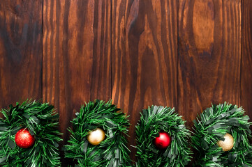 Christmas or New Year decoration background: pine branches, colorful glass balls on the dark, rustic wooden background and with space for text. Minimalist background. Top View