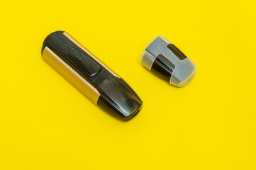 Electronic cigarette for smoking and spare cartridge on yellow background