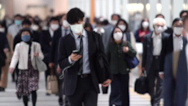 Covid-19 : Crowd of people wearing masks walking to work in Tokyo, JAPAN / slow motion