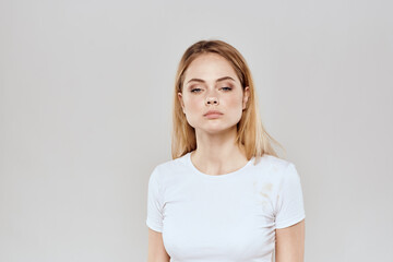 Obraz premium cheerful blonde in a white t-shirt gesturing with her hands light background