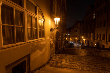 
street lights in the center of Prague and a cobbled sidewalk in the center of the old town at night