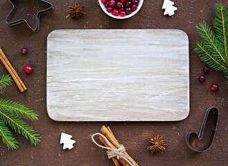 Culinary Christmas background with aromatic spices, baking ingredients and cuttings for Christmas cookies on a brown concrete background.