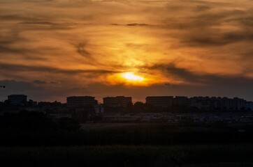 Urban panorama with sun at sunset