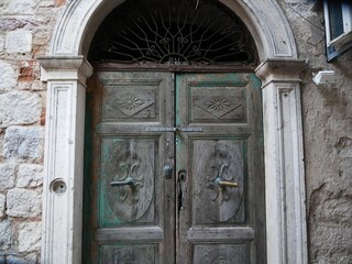 Fototapeta na wymiar Old wooden door against a grey wall