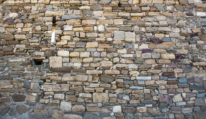 Ancient stone wall made of stones of different sizes.