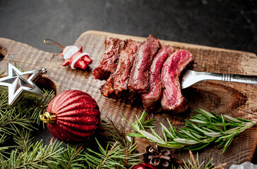 Different degrees of roasting of steak on a meat fork for Christmas on a background of a stone with...