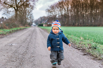Fototapeta premium Happy toddler running on footpath