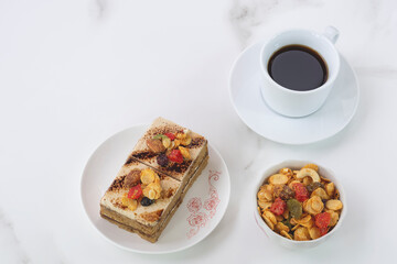 Coffee cake with toppings and black coffee on marble tabletop at coffee shop 