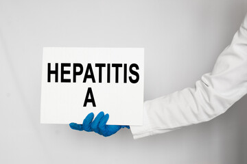 The doctor's blue - gloved hands show the word HEPATITIS A - . a gloved hand on a white background. Medical concept. the medicine