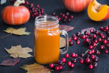Halloween cocktail, pumpkin orange drink with spices. Dark vintage dirty background. Creative atmospheric decoration