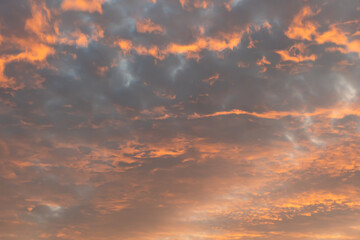 Red cloudy evening sky, red and grey clouds with abstract structure and blue sky