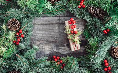 Naklejka na ściany i meble Christmas tree branches with gift box on wooden background