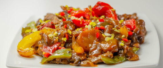 Cooked marinated beef slices with a savory black beef sauce, peppers and onions