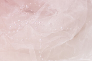 
pink background made of transparent shiny fabric with pearls