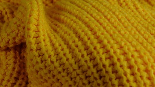 Woolen fabric texture. Yellow knitted fashion wool cloth closeup background. Winter textile industry macro 360 motion.