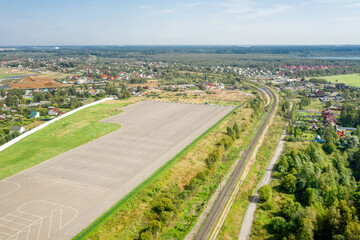 Fototapeta na wymiar Aerial view of empty parking spaces near warehouse buildings of business park in countryside