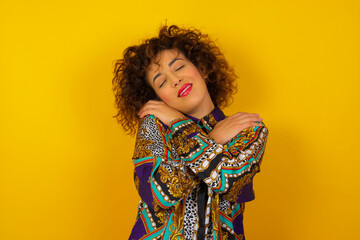 Portrait of nice-looking sweet lovable attractive winsome fascinating well-groomed lovely calm peaceful cheery girl hugging herself isolated over bright background