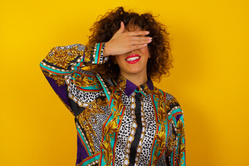 Happy Caucasian young woman closing eyes with hand going to see surprise prepared by boyfriend standing and smiling in anticipation for something wonderful. Young lady covering face with hand.