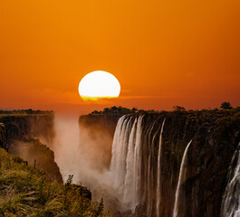 Supersized sun over Victoria Falls in Zambia - obrazy, fototapety, plakaty