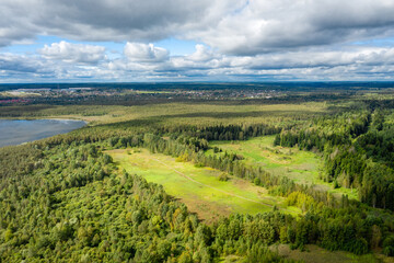 Fototapeta na wymiar Aerial view of the countryside and a circular lake in the middle of the forest.