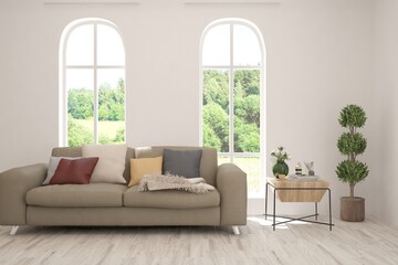 White living room with sofa and summer landscape in window. Scandinavian interior design. 3D illustration