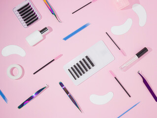 Things for the work of lash-makers, artificial eyelashes, microbrachis, glue, tweezers, combs, brushes for eyelash extensions. Eyelash extension, painting of eyebrows. Top view, pink background.