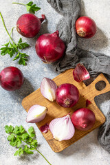 Purple Onions. Fresh whole purple onions and one sliced onion on a stone countertop. Top view flat lay background.