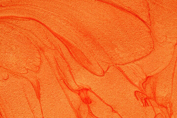 Abstract painted background in orange color with gold mother-of-pearl and red veins. Textured sand...