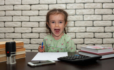 A little girl sits at an office desk with her mouth open and takes notes. office work