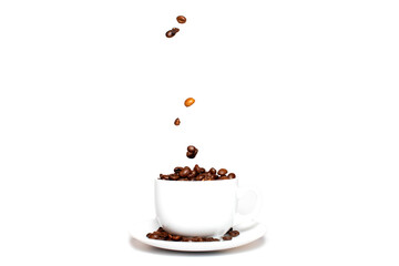 Roasted coffee beans falling into a coffee cup on a saucer with a white background, close-up, coffee wallpaper.