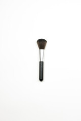 A single makeup brush on the white background