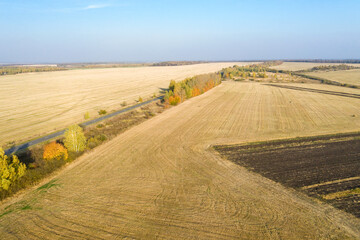Fototapeta na wymiar Aerial view of harvested agricultural fields and the highway in autumn day