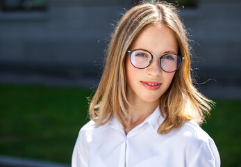 Portrait of a young beautiful girl in white shirt