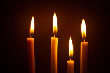 Many burning candles on black background