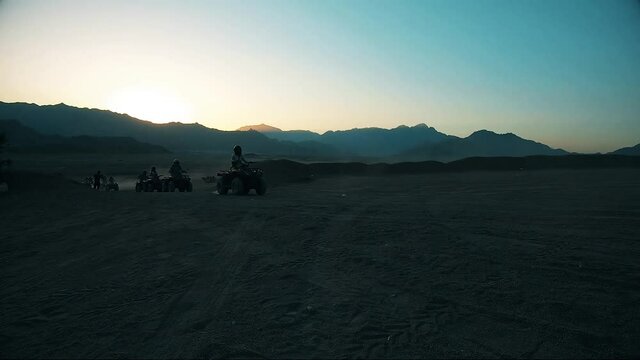 Riding through the desert and mountains in Egypt. At sunset of a hot day, tourists drive through the desert into the mountains to the biduins. 