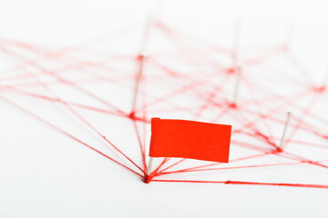 A large mesh of pins tied together with a red cord. Communication, network concept.