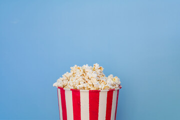 A bucket full of popcorn on a blue background