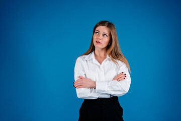 Beautiful thinking and doubting business woman isolated on blue background