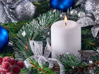 Background of the New year.Candles burn on glass candlesticks, against the background of pine branches and Christmas decorations.