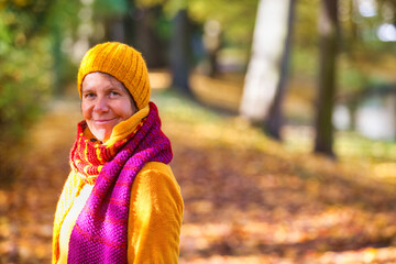 woman in her 50s walking in park in autumn