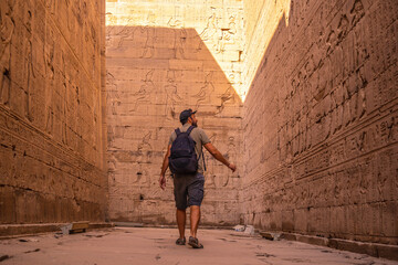 A young tourist in the hieroglyphic corridors of the Edfu Temple in the city of Edfu, Egypt. On the...