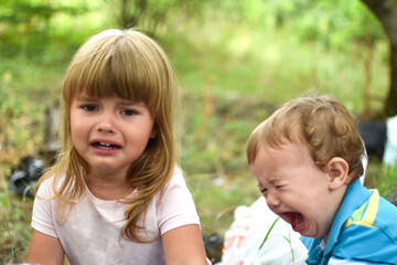 Fototapeta na wymiar two little crying baby girls outdoor. upset girls sisters