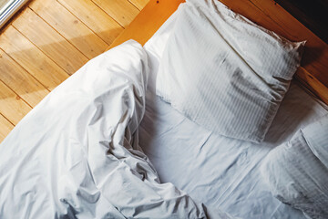 Bed and pillows with white bedsheet in the sunny room