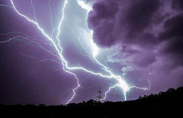 Blitze bei Gewitter in der Nacht mit Strommast